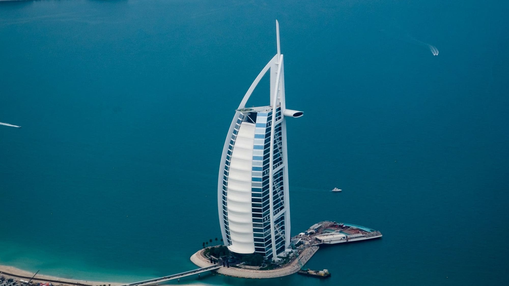 The Burj Al Arab standing in turquoise water off the Dubai coast