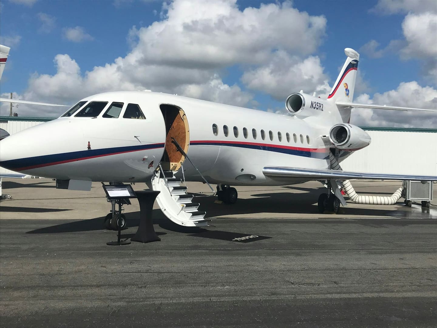 A private jet on the tarmac with its stairs down, ready to board