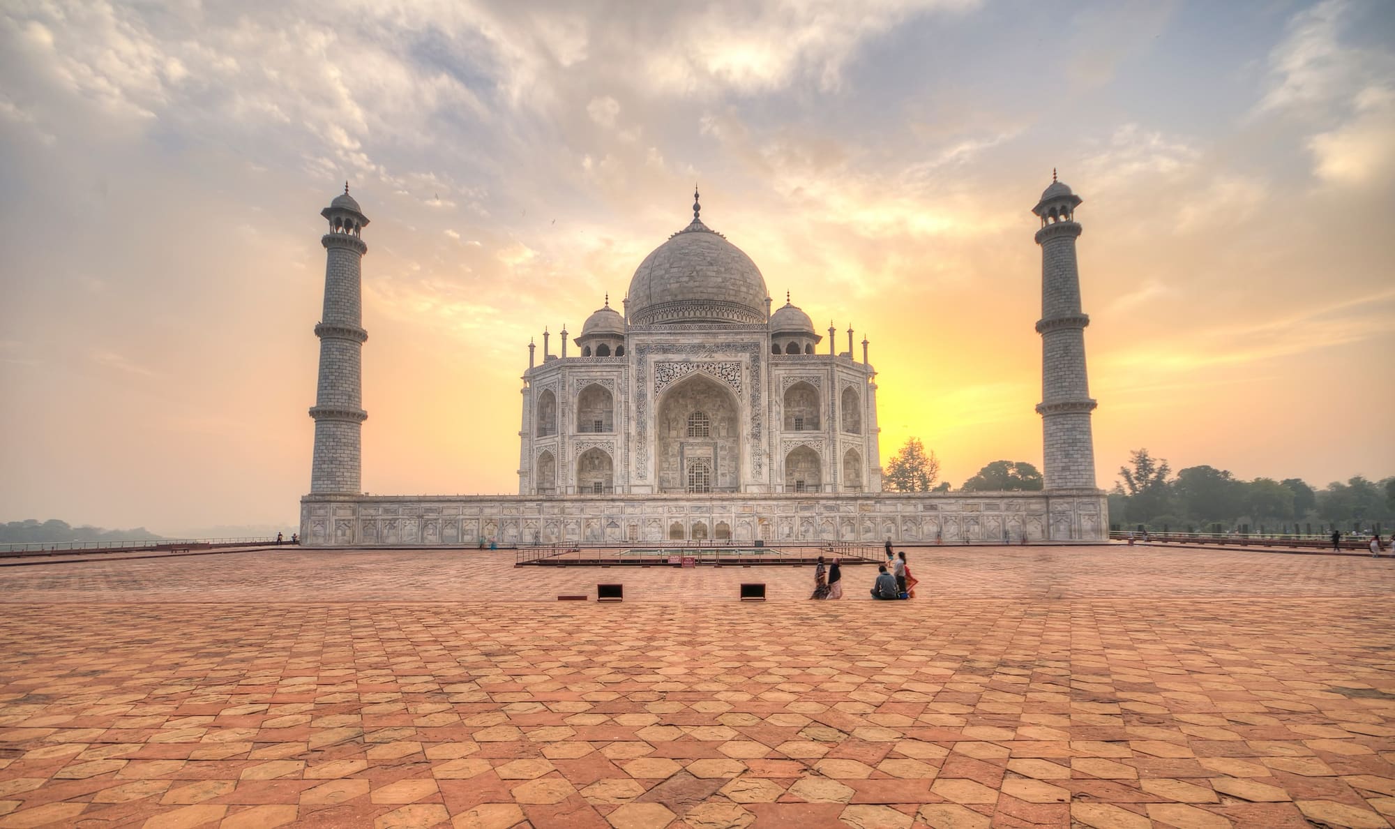 The Taj Mahal at sunrise seen across its empty marble plinth