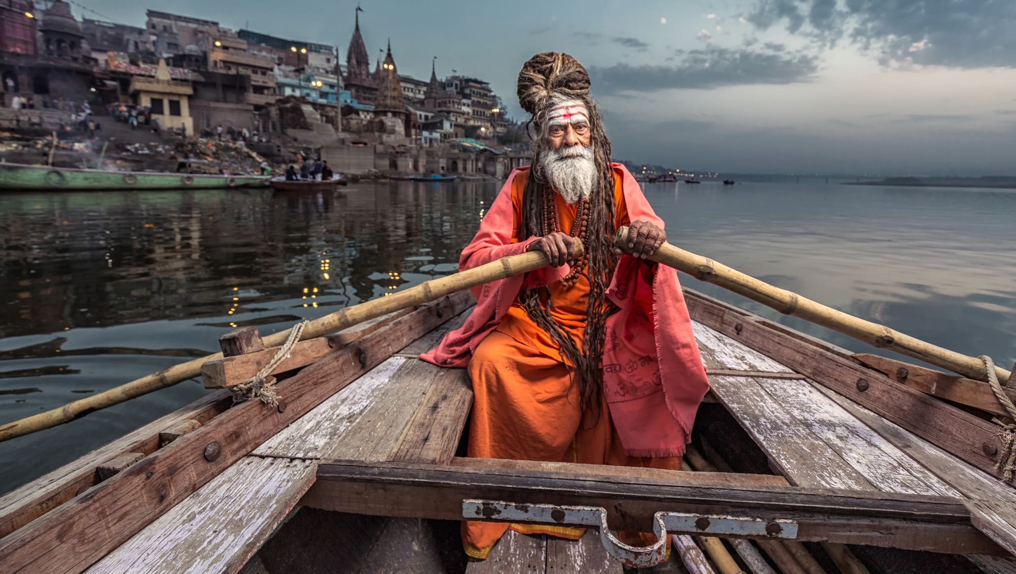 A woman in a red sari on the steps of the Varanasi ghats